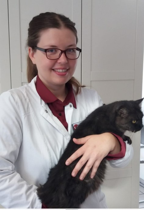 Tierärztin hält eine schwarze Katze auf dem Arm